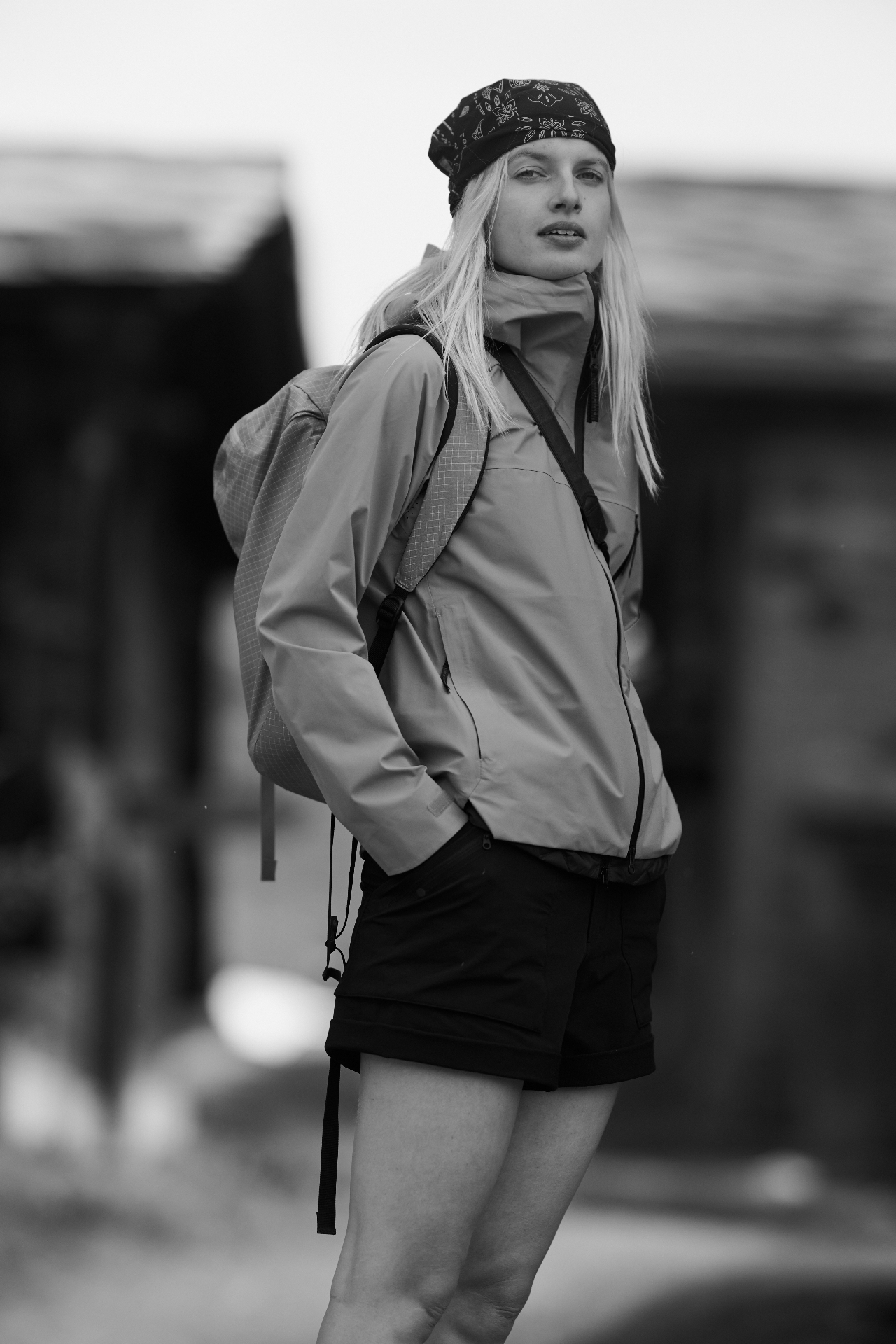 Woman in beige technical shell jacket with bandana and ripstop backpack in Zermatt village