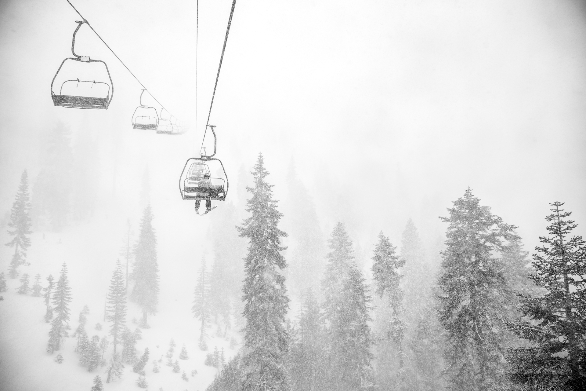 A chairlift in heavy snowfall and low visibility