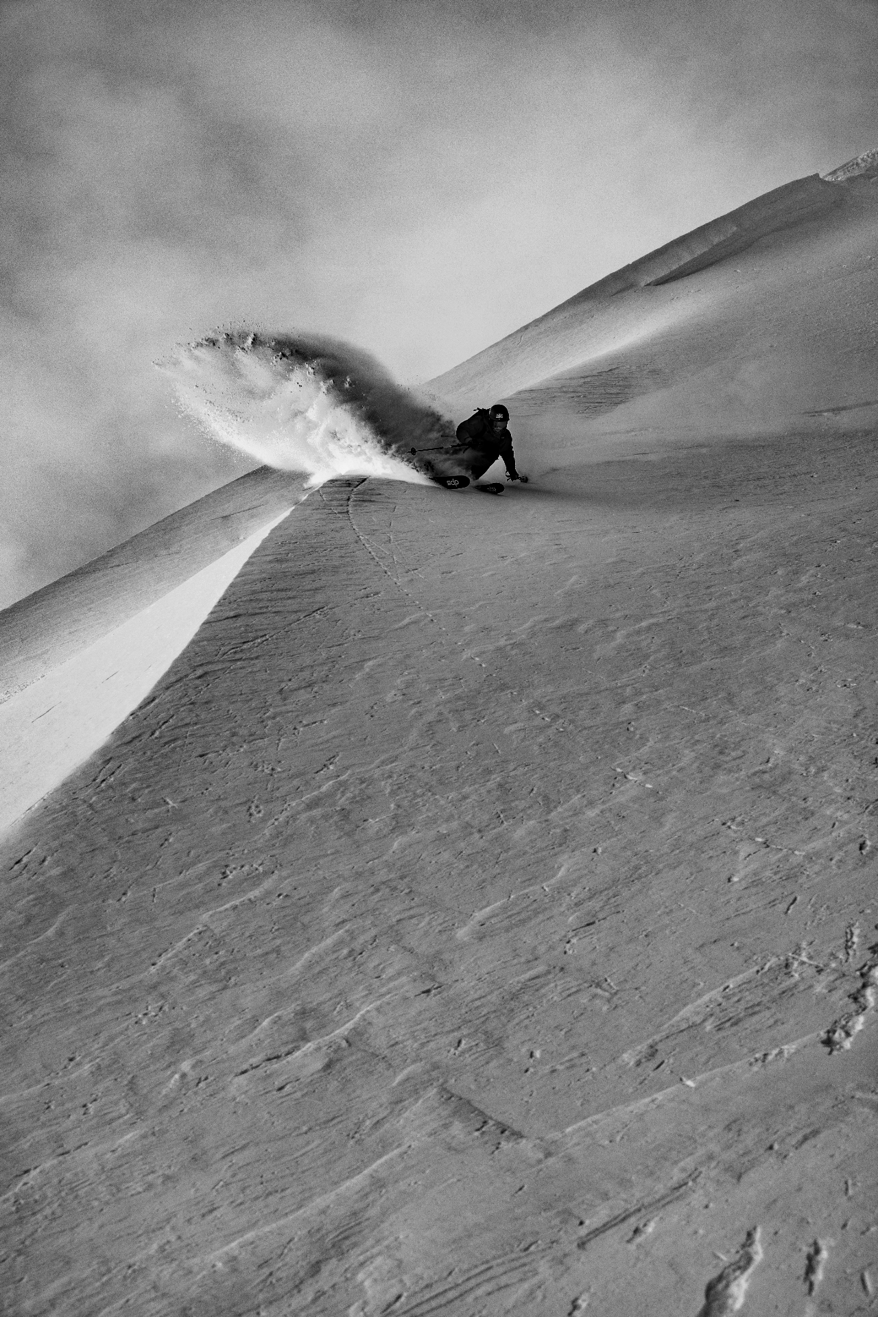 A freeride skier on a steep powder spine above Zermatt