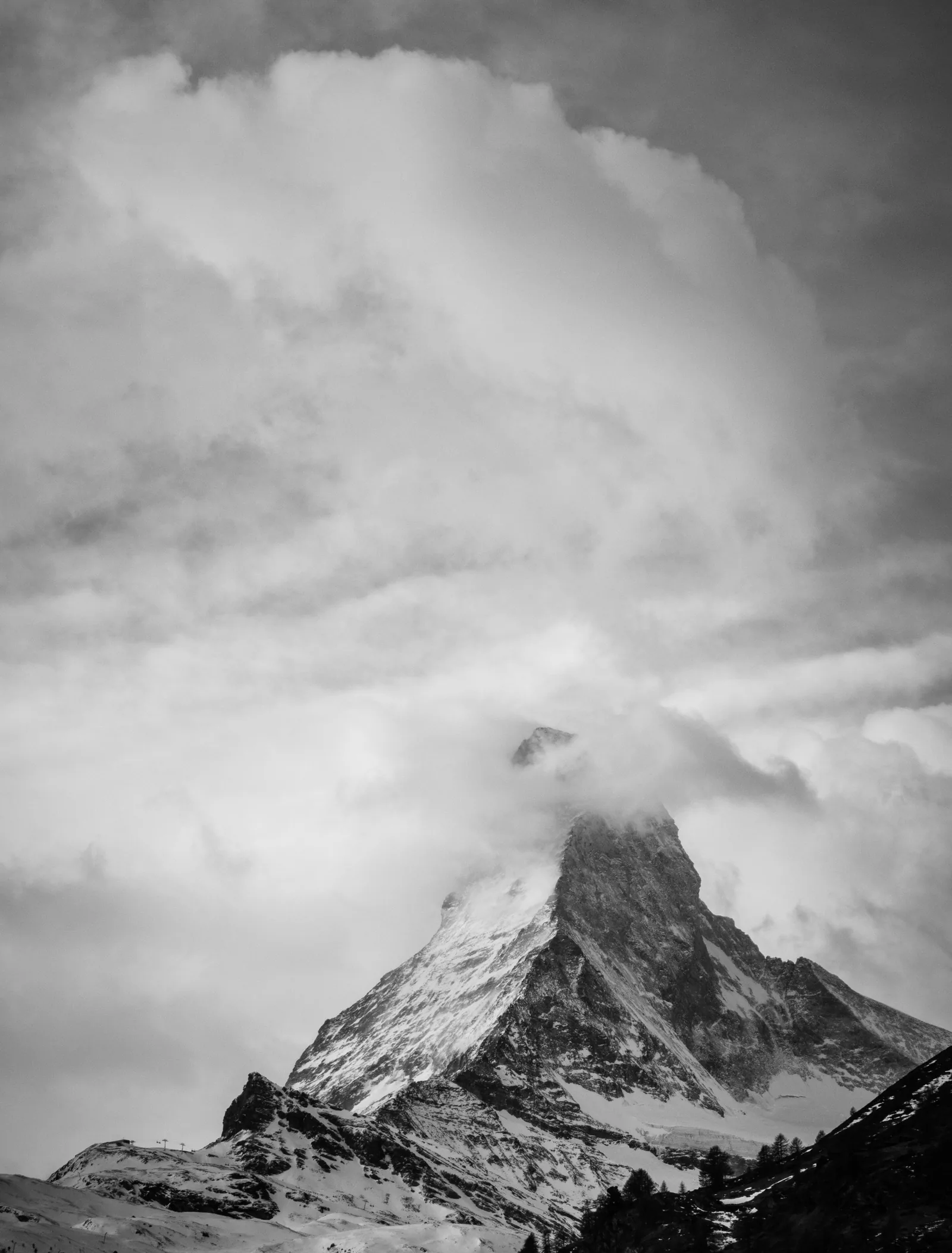 Black-and-white view of the Matterhorn with its upper face swallowed by storm cloud