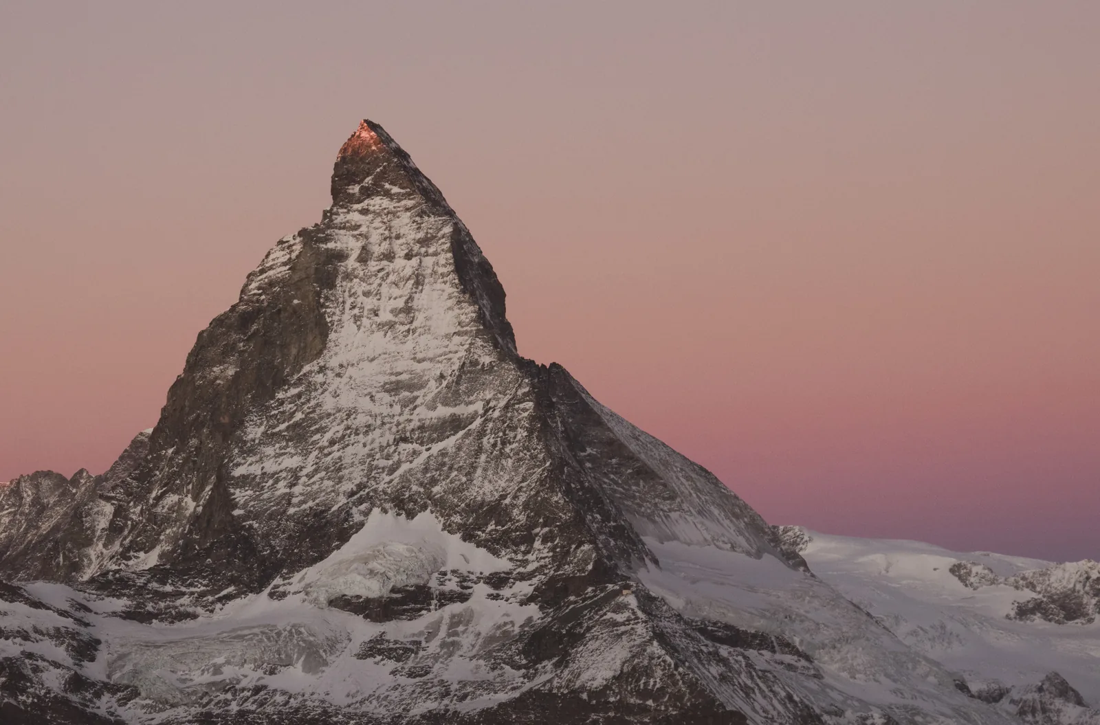 The Matterhorn at dawn with pink alpenglow on the summit and a rose-coloured sky